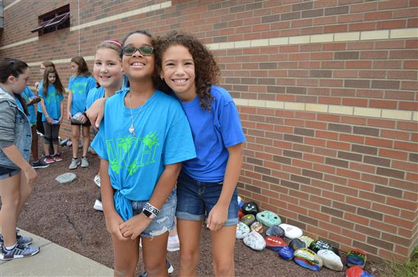 Students pose for a picture after placing their rocks in the MCH rock garden  