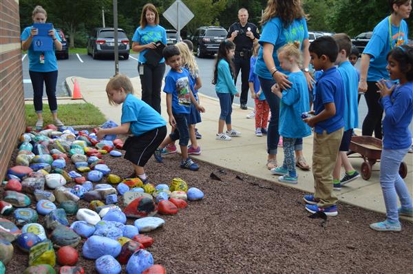 Students place their rocks in the MCH rock garden 